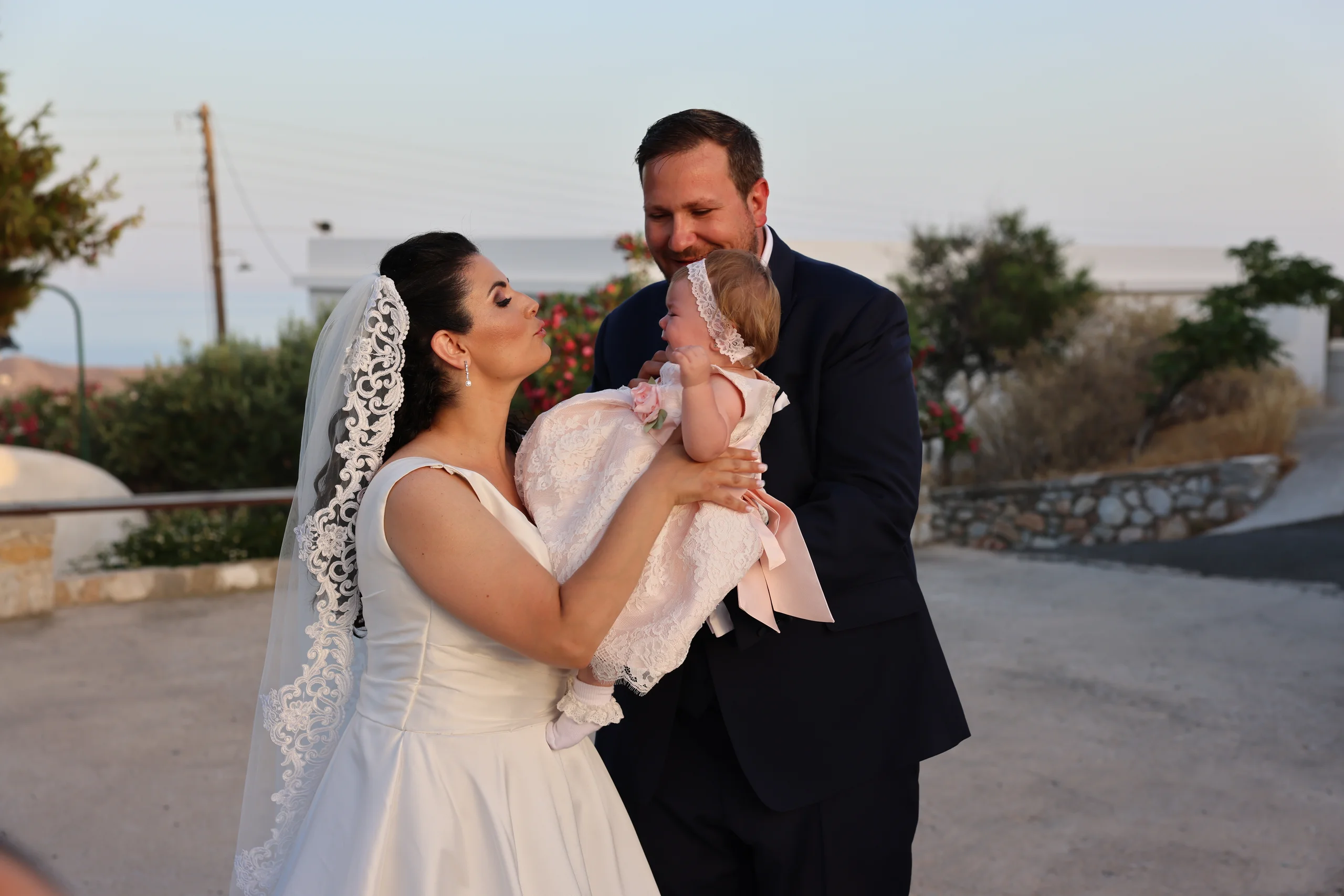Couple holding baby at wedding ceremony.