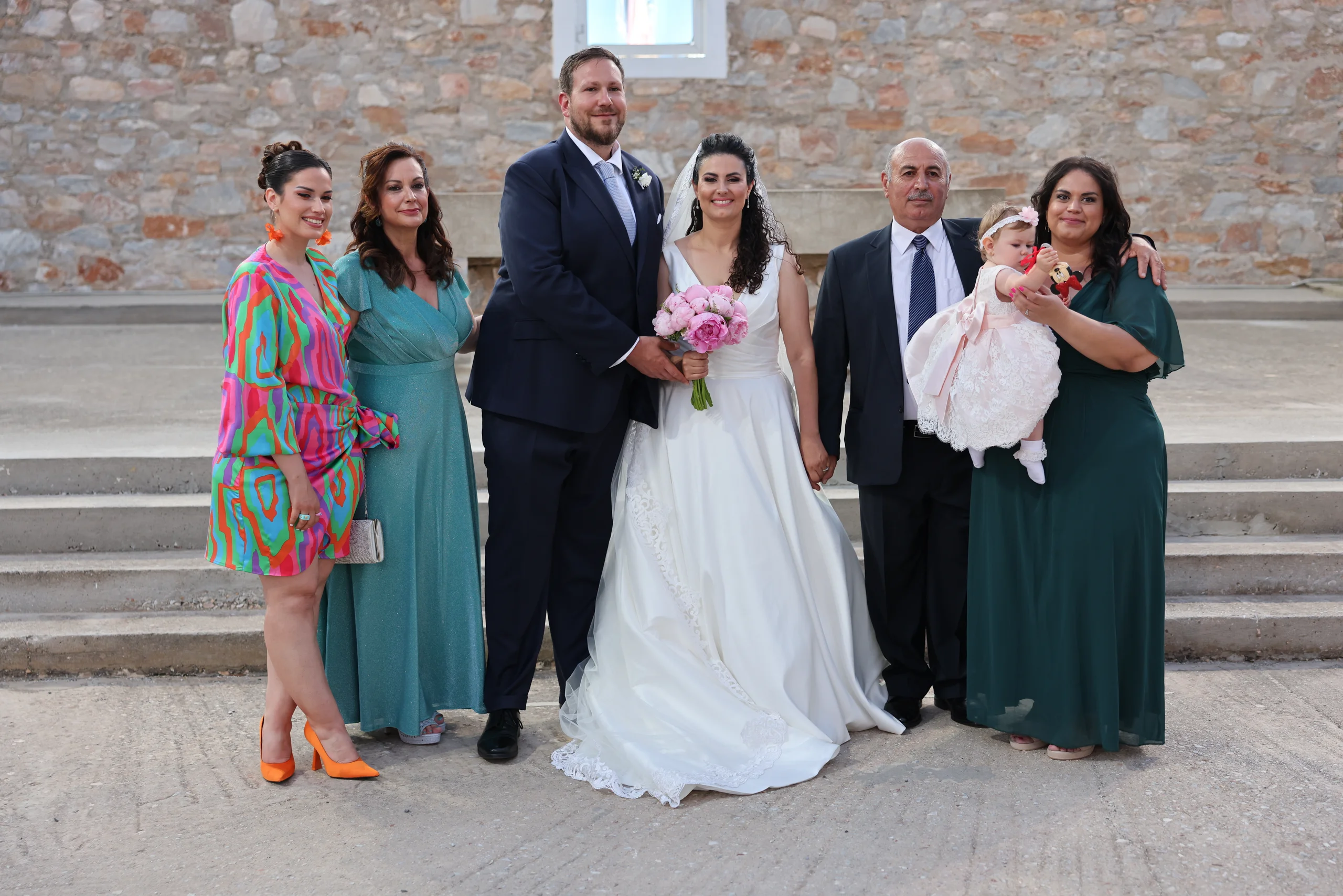 Family group photo at outdoor wedding ceremony.