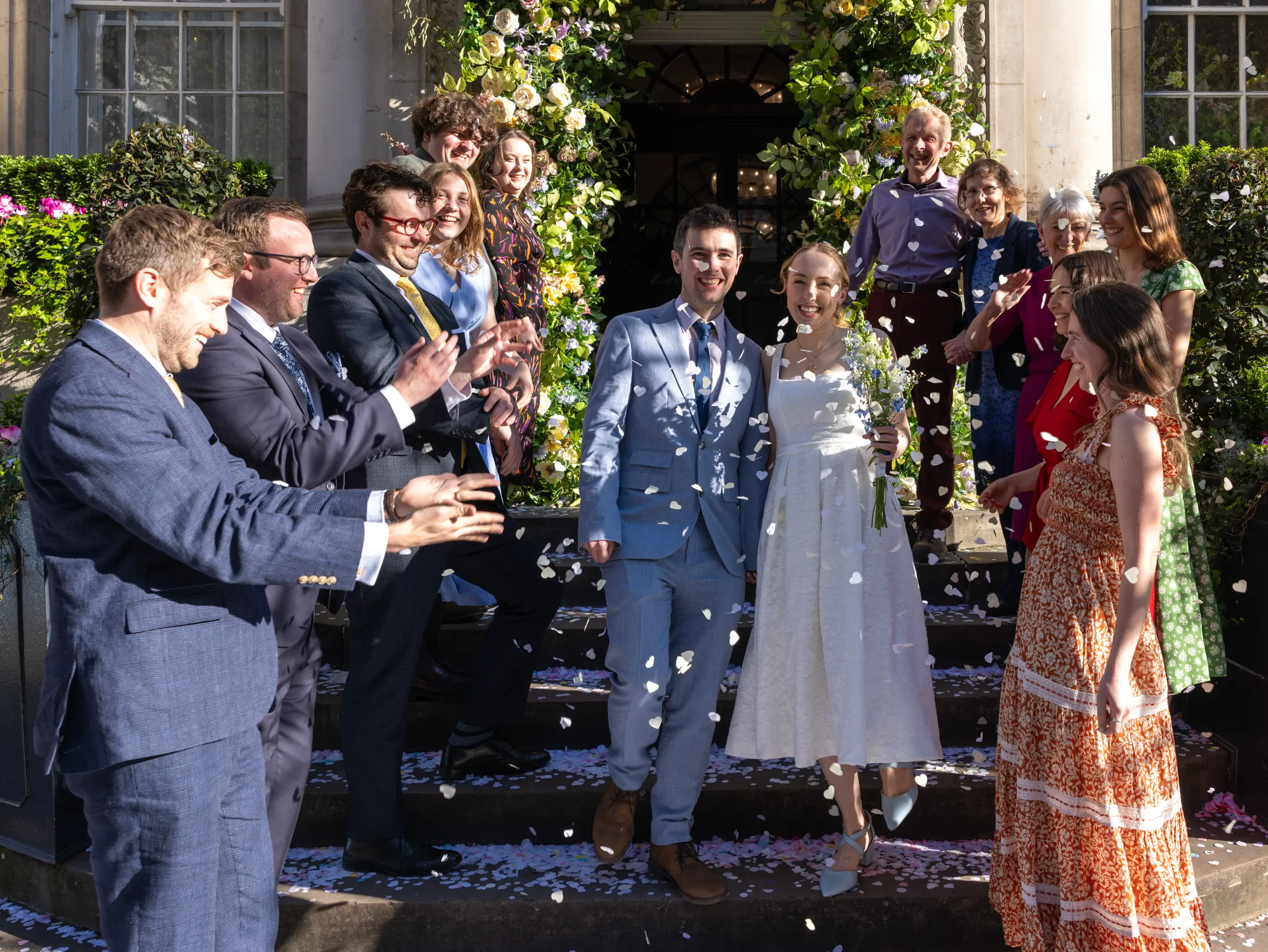 Bride and groom walking through confetti outside venue